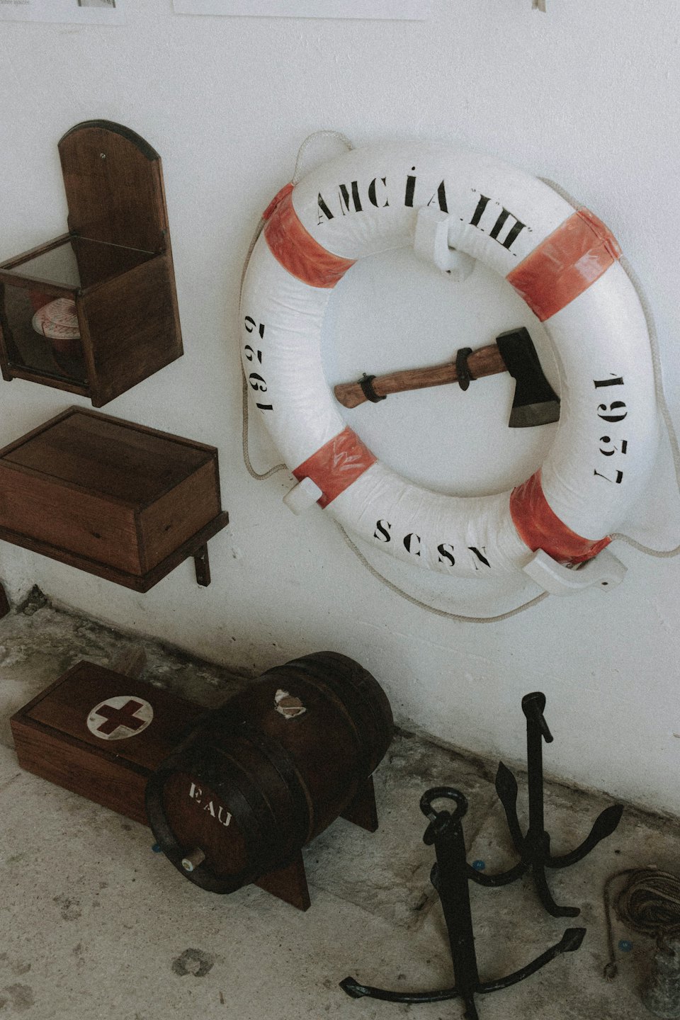 Decorazioni nautiche vintage includono un salvagente, ancore e casse di legno.